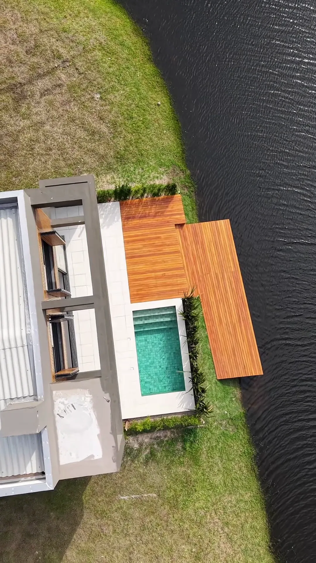 Vista aérea da piscina e do deck sobre o lago